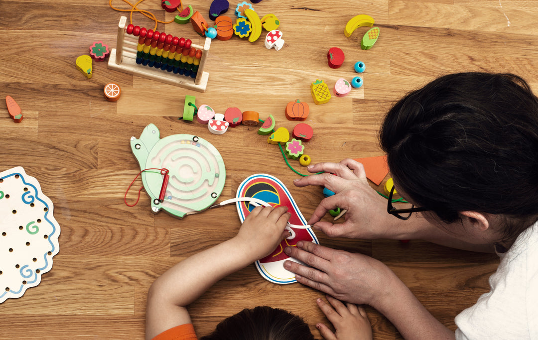 Blossom & Bloom Kids sensory play helps cognitive development with mother and child lacing and building a necklace