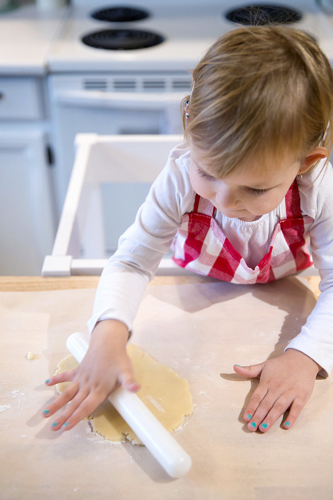 Blossom & Bloom Kids designed to inspire creativity with child rolling dough with white rolling pin