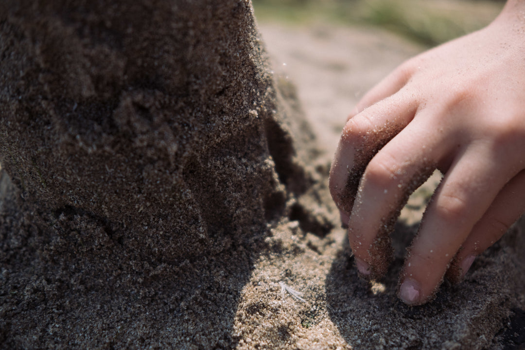 Blossom & Bloom Kids sensory play with kids hand in the sand