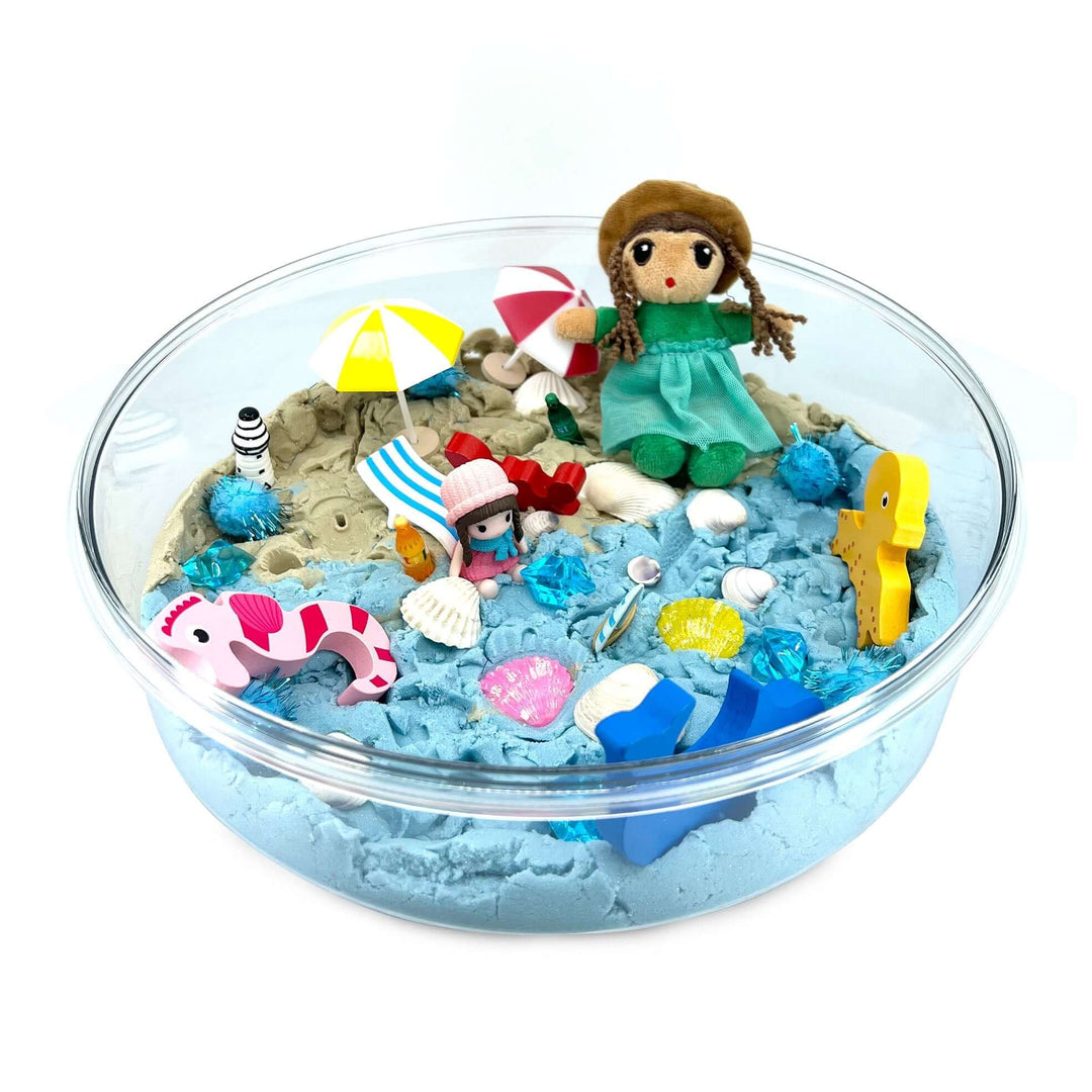 Beach Day Kinetic Sand Kit with Organic Cotton Beach Figure, Umbrellas, Beach Chairs, Bottles, Seashells, Wooden Sea creatures and more from Blossom & Bloom Kids - Beach Day, Ocean Theme Set with Kinetic Sand - Blossom & Bloom Kids