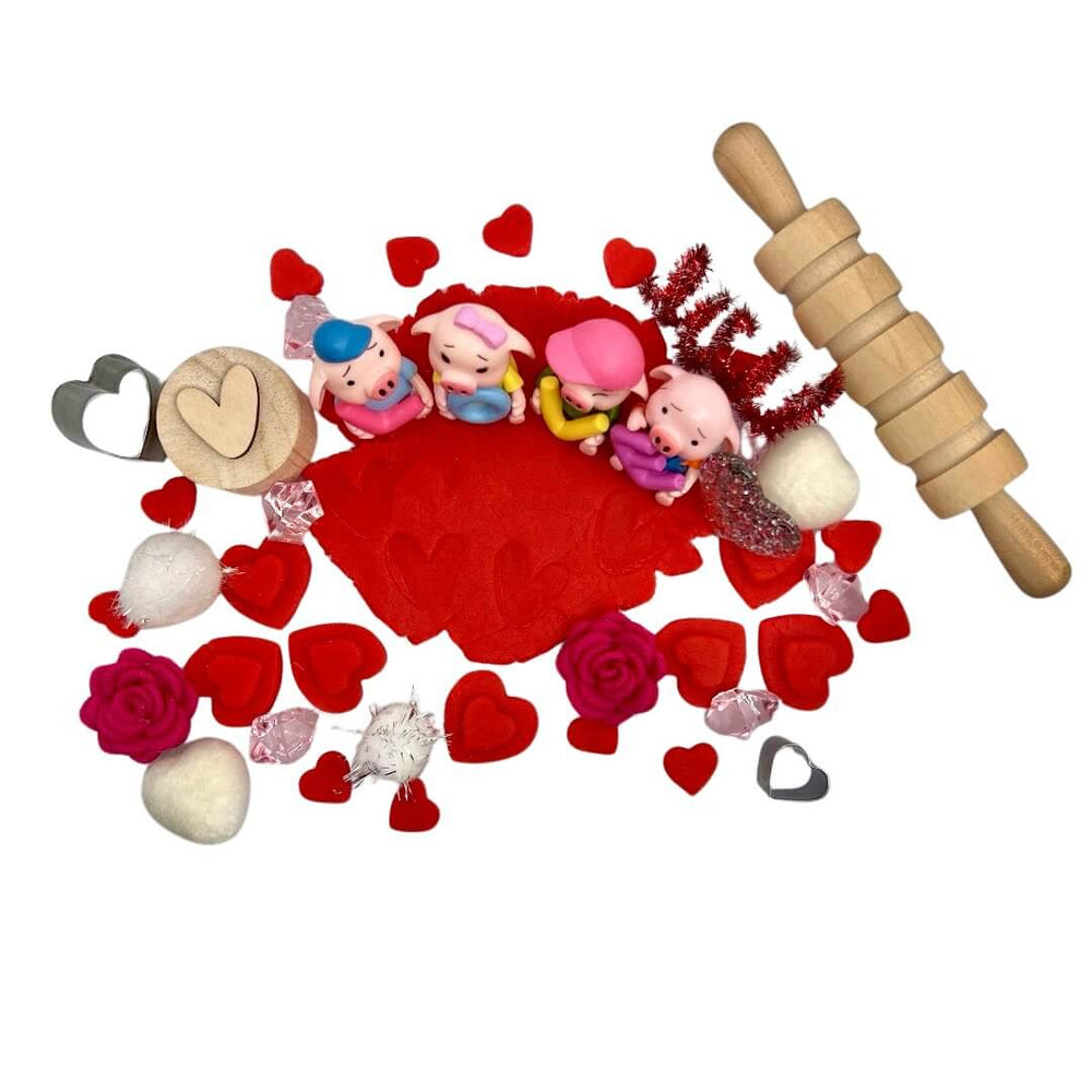 Top view of Toy pigs with letters LOVE, Heart shaped cutters and stamps, felt flowers, rolling pin, and red playdough with heart stamped included in All You Need Is Love Bloom Bag from Blossoms & Bloom Kids - All You Need Is L-O-V-E, Playdough Kit - Blossom & Bloom Kids