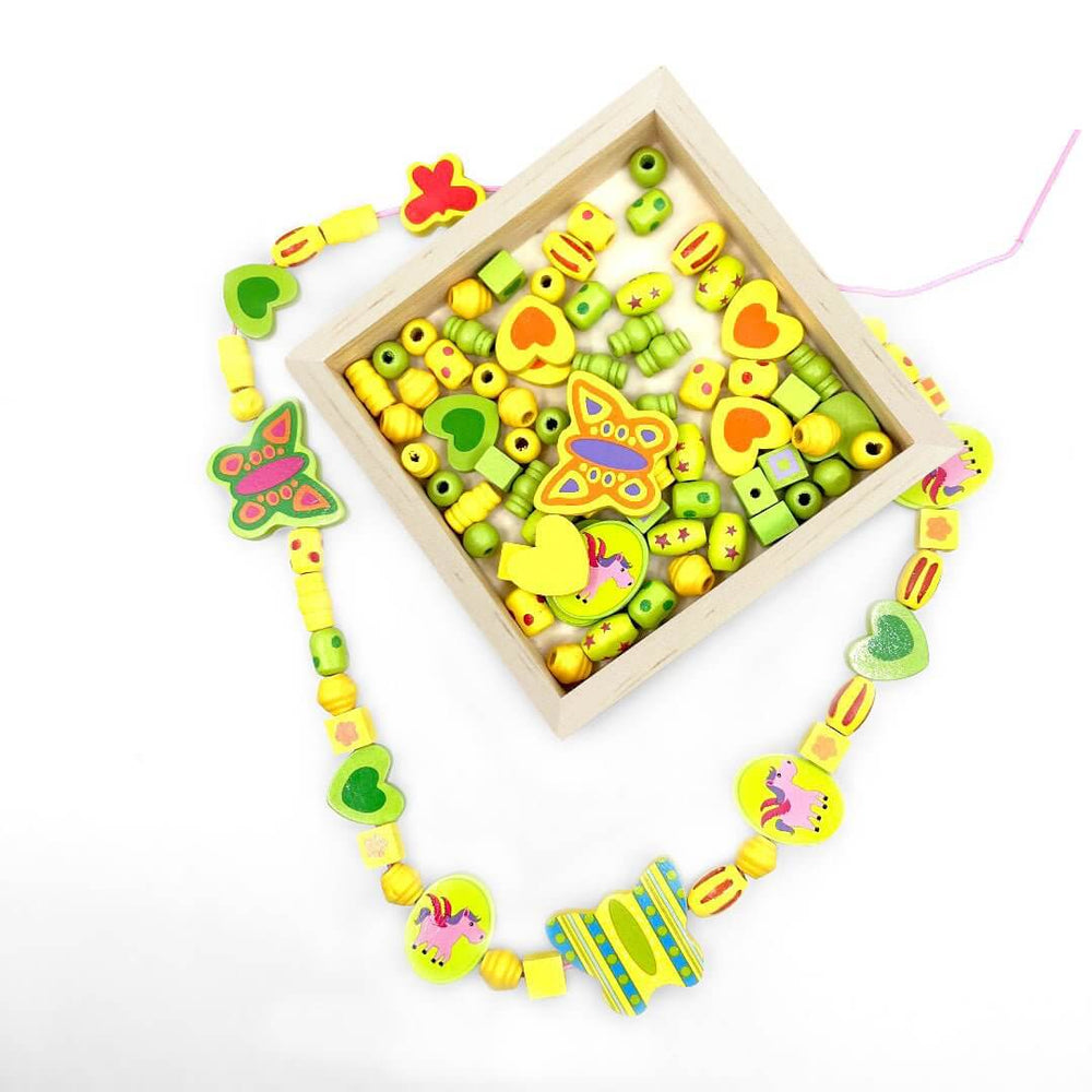 Wooden Bead Unicorn Necklace Kids learning activity with wooden try and beads of different shapes from Blossom & Bloom Kids - Wooden Bead Unicorn Necklace - Blossom & Bloom Kids